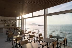 a restaurant with tables and chairs and a view of the water at Les Bords De Mer in Marseille