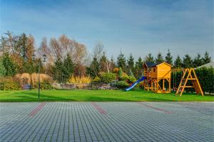 un parque infantil con tobogán y estructura de juegos en Hotel "Piast", en Tuczempy