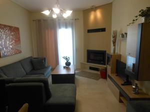 a living room with a couch and a television at Meteora Panorama at the city Center in Kalabaka