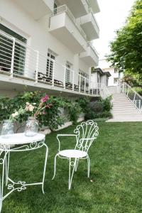 two chairs and a table in the yard of a house at Hotel Houston in Rimini