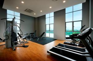 a gym with cardio equipment in a room with windows at KIP Hotel in Kuala Lumpur