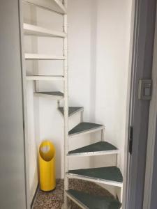 a white staircase in a room with a yellow trash can at Bright apartment in the heart of Venice in Venice