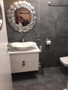 a bathroom with a mirror and a toilet at Etna Polonia Apartamenty in Kołobrzeg