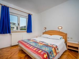 um quarto com uma cama e uma janela com cortinas azuis em Apartment Hilde Blue-8 by Interhome em Medulin