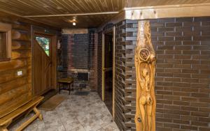 un porche con una pared de ladrillo y una puerta de madera en Trīssaliņas, en Aumeisteri