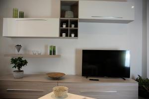 a living room with a flat screen tv on a dresser at Da Sabbi in La Spezia