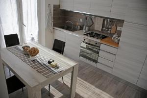 een keuken met een tafel, een fornuis en een wastafel bij Da Sabbi in La Spezia
