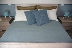 een bed met blauwe en witte kussens erop bij Da Sabbi in La Spezia