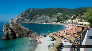 een strand met parasols en mensen op het strand bij Da Sabbi in La Spezia