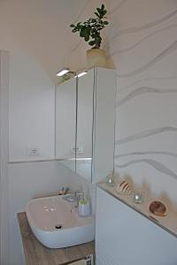 een witte badkamer met een wastafel en een potplant bij Da Sabbi in La Spezia +26 foto's