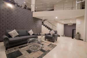 a living room with a couch and chairs and a staircase at W Residence Kandy in Kandy