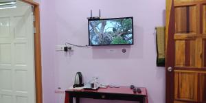 a tv on the wall of a room with a table at Jazepuri - Jaze 2 in Kuching