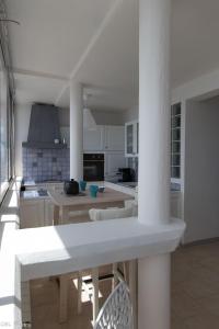 a kitchen with white cabinets and a table and chairs at L'Eternel Estivant in Sète