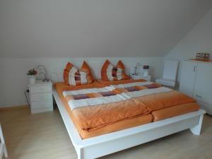 a bedroom with a large bed with orange pillows at FEWO1 1OG Scheldt in Nümbrecht