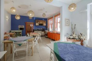 a kitchen and dining room with blue walls and tables at Red Carpet Hostel in Krakow