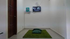 a room with a green pillow on a green rug at Homestay Rgee in Kuantan