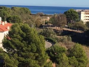 a bridge over a river with trees and the ocean at Llastre in Hospitalet de l'Infant