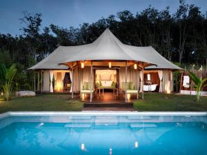 a tent with a swimming pool in front of a house at 9 Hornbills Tented Camp in Ko Yao Noi