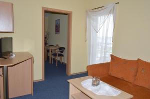 a hotel room with a couch and a window at Penzion Oaza Prievidza in Prievidza