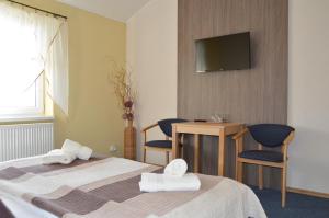 a hotel room with two beds and a flat screen tv at Penzion Oaza Prievidza in Prievidza