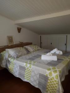 a large bed with two towels on top of it at Casa- Maresias 3 minutos da praia in Maresias