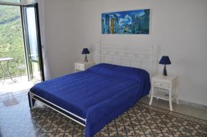 a bedroom with a blue bed and two night stands at villa verde sul mare in Vietri sul Mare