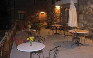 d'une terrasse avec des tables, des chaises et un parasol. dans l'établissement Eido das Estrelas, à Valdín