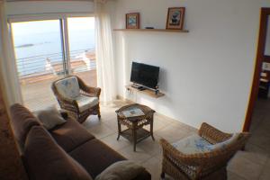sala de estar con sofá, sillas y TV en Agi Rodas Apartments, en Roses