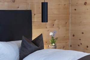 Schlafzimmer mit einem Bett mit schwarzen und weißen Kissen in der Unterkunft Hotel Baer & Post Zernez in Zernez