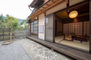 a japanese house with a courtyard with a window at Konpira Machiya USU in Kotohira