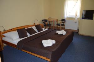 a bedroom with a large bed with towels on it at Penzion Oaza Prievidza in Prievidza