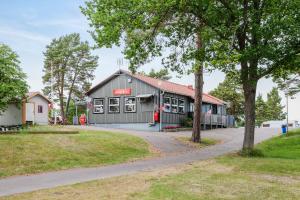 奧斯卡港的住宿－First Camp Gunnarsö-Oskarshamn，前面有一条路的黑色建筑