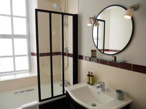 a bathroom with a shower and a sink and a mirror at The Fleece in Witney