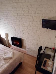 a bedroom with a bed and a desk and a fireplace at Tihiy dvorik in Saint Petersburg