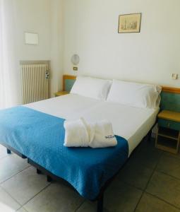 una camera da letto con un letto e due asciugamani di Hotel Dolores a Rimini