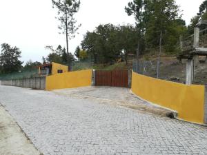 eine leere Straße mit einem gelben Zaun und einem Gebäude in der Unterkunft Casas de Canavezes in Marco de Canavezes