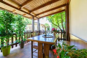 a patio with a wooden table and potted plants at bungalow campeggio madonnina in Domaso