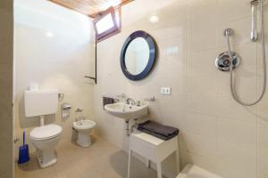 a bathroom with a toilet and a sink and a mirror at bungalow campeggio madonnina in Domaso