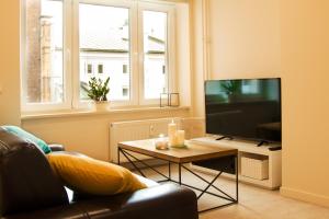 een woonkamer met een televisie en een tafel bij Luksusowy apartament Świętego Jana na Rynku in Krakau
