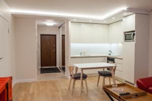 ヴィリニュスにあるNatalex Apartmentsのテーブルとキッチンのあるリビングルーム