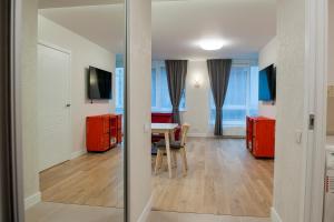 a living room with a table and red cabinets at Natalex Apartments in Vilnius