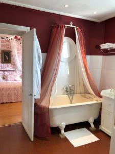 La salle de bains est pourvue d'une baignoire, d'une fenêtre et d'un lit. dans l'établissement VILLA la GLORIETTE, à Rouen