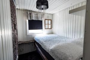 a small bedroom with a bed and a window at Airisto Hill & Inn - Two Beach Cabins in Haverö +10 photos
