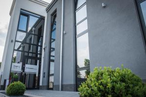 an office building with large windows and bushes at Triumph Inn Pension in Rangsdorf