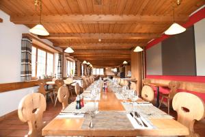 a long dining room with wooden tables and chairs at Hotel Ucliva in Waltensburg