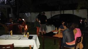 a group of people sitting at a table at night at Aura City Hostel in Anuradhapura