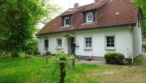 a white house with a red roof at Ferienwohnungen & Bungalow Karlchen in Korswandt