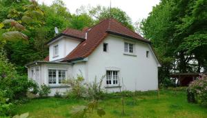 a white house with a brown roof at Ferienwohnungen & Bungalow Karlchen in Korswandt