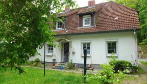 a white house with a red roof at Ferienwohnungen & Bungalow Karlchen in Korswandt