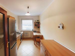 kuchnia ze stołem i lodówką ze stali nierdzewnej w obiekcie Gdynia Baltic Apartment w mieście Gdynia
